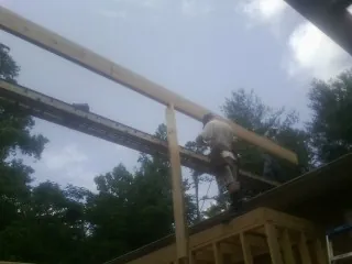 Carpenter setting a ridge beam over a new addition frame — Ice Dam Removal by Roofing Brothers in Rio Vista