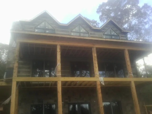 Dormers and porch framing on a large log home under construction — Roof Coating work by our crew in Rio Vista